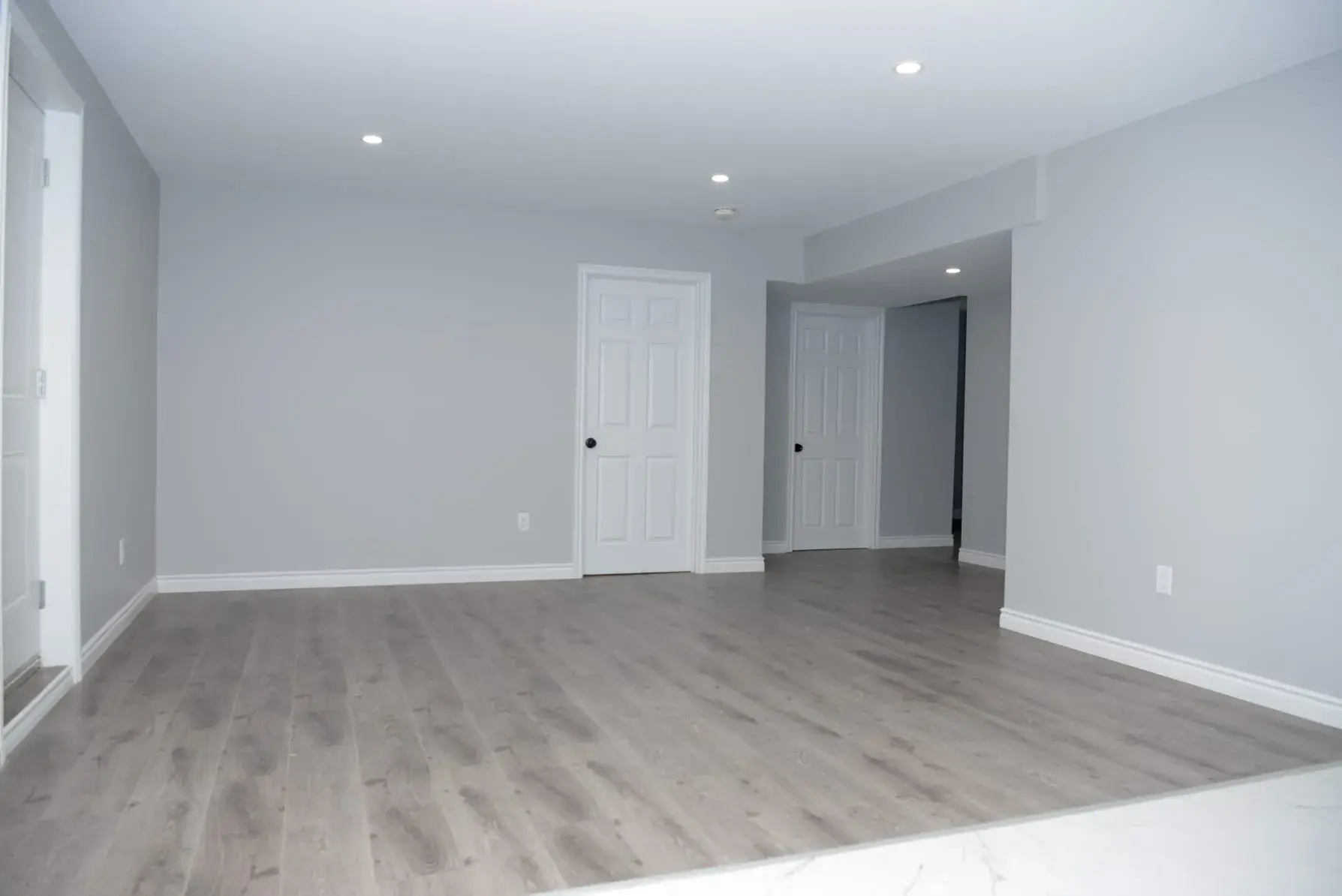 Finished basement renovation with complete trim, lighting, and living space detail
